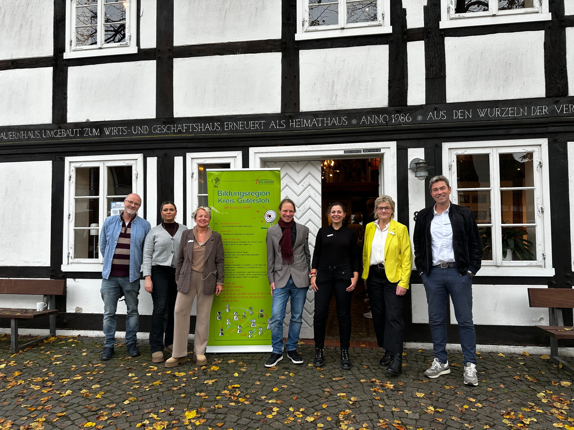 Peraonen stehen vor einem Gebäude