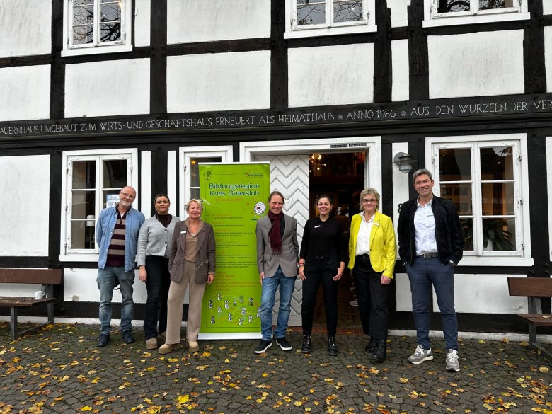 Peraonen stehen vor einem Gebäude