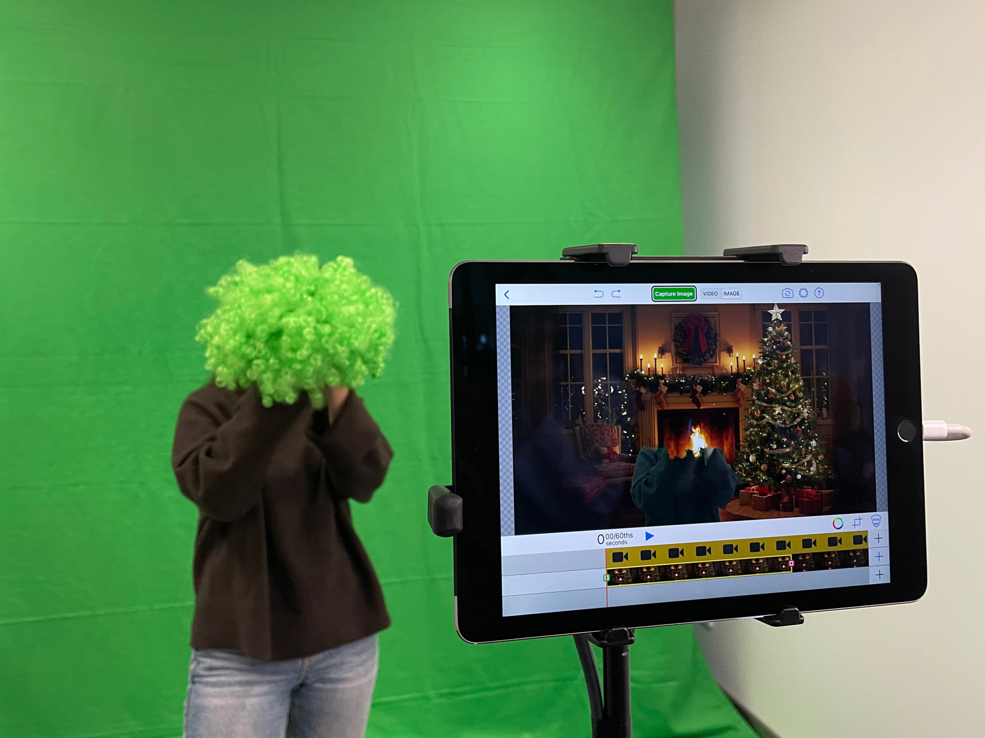 Person steht vor einem Greenscreen.