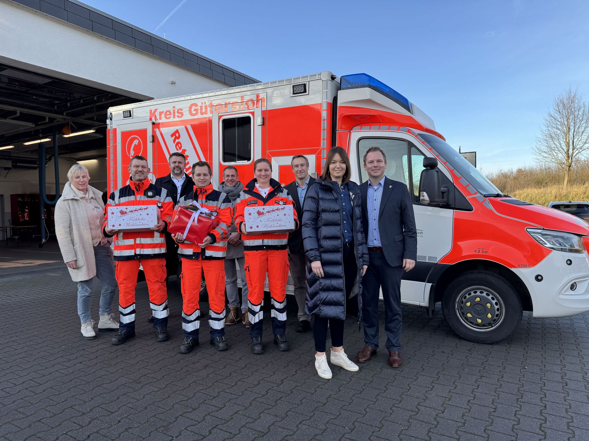 Rettungswachenbereisung, Station in Versmold: Geschenke von Landrätin Ina Laukötter (2.v.r.) und Bürgermeister Michael Meyer-Hermann (r.) bei der Rettungswachenbereisung in Versmold (v.l.): Dr. Angela Lißner, Patrick van Diesen, Markus Brock, Sven Ranocha, Jürgen Theis, Vivianne Theilmann und Sven Rabaschus. 