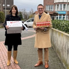 Landrätin Ina Laukötter und Bürgermeister Robin Rieksneuwöhner mit Geschenken in der Hand auf dem Weg zur Rettungswache Verl.