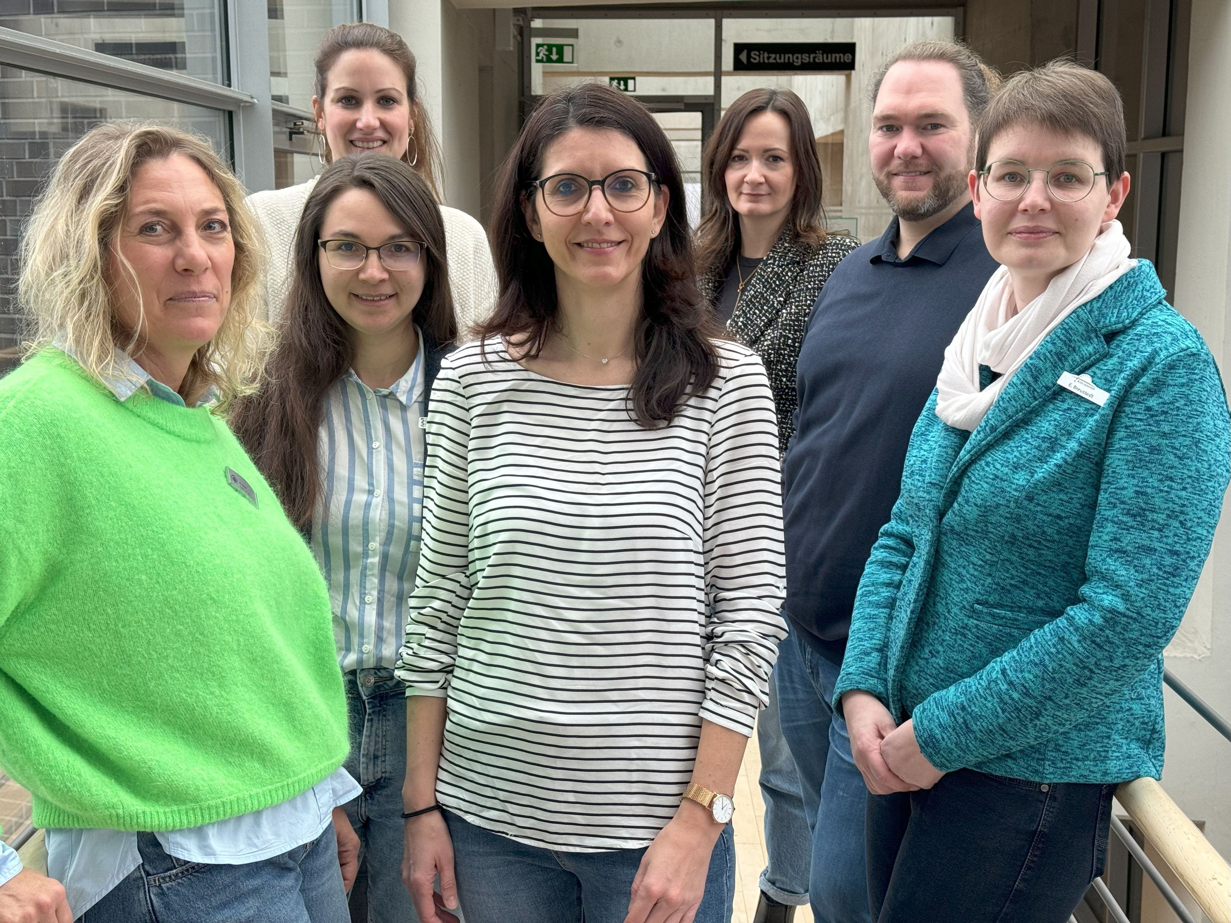 Personen stehen nebeneinander im Foyer des Kreishauses und blicken in die Kamera.