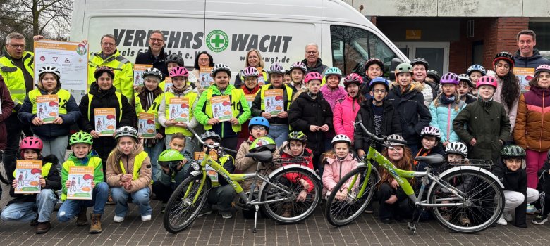 Erwachsene und Kinder blicken in die Kamera.