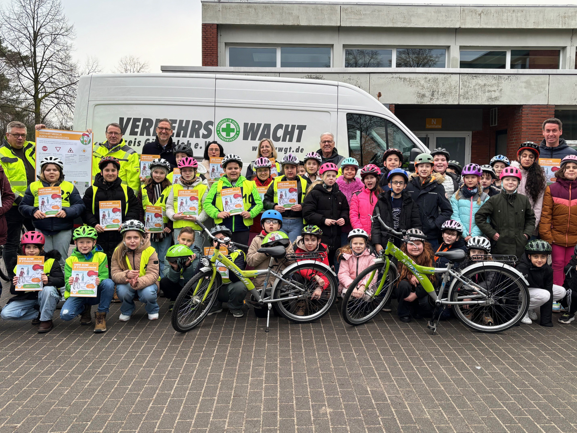 Erwachsene und Kinder blicken in die Kamera.