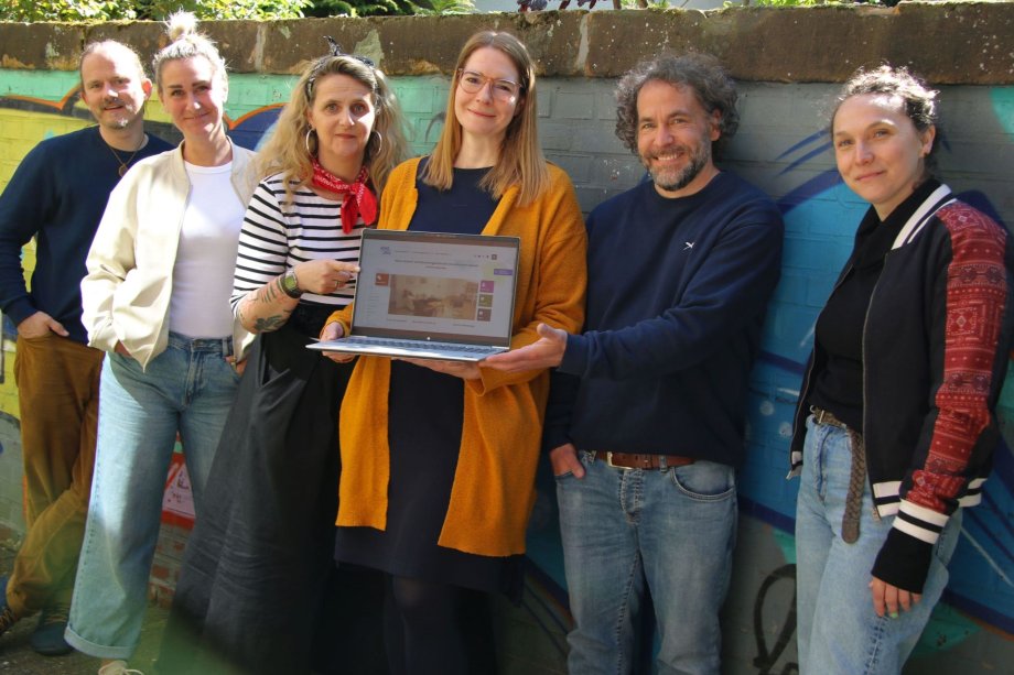 Das Team des Wendepunktes mit einem Laptop auf dem die Startseite der neuen Homepage zu sehen ist.