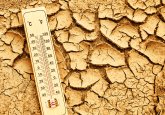 Climate change concept. Thermometer on arid, cracked soil representing extreme heat and drought conditions. Hitze