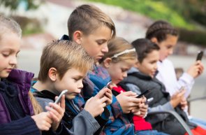 Outdoor portrait of girls and boys playing with phones