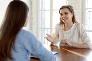 Happy millennial female job seeker making self-presentation to employer.