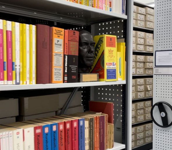 Regale mit Büchern und Kartons im Magazinraum.