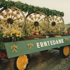 Landwirschaftlicher Anhänger mit geschmückten Wagenrädern und dem Schriftzug "Erntedank".