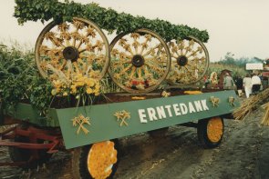 Erntedankumzug Clarholz 1986 Landwirschaftlicher Anhänger mit geschmückten Wagenrädern und dem Schriftzug "Erntedank".