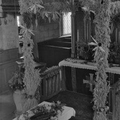 Ein Gabentisch steht vor einem geschmückten Altar. 