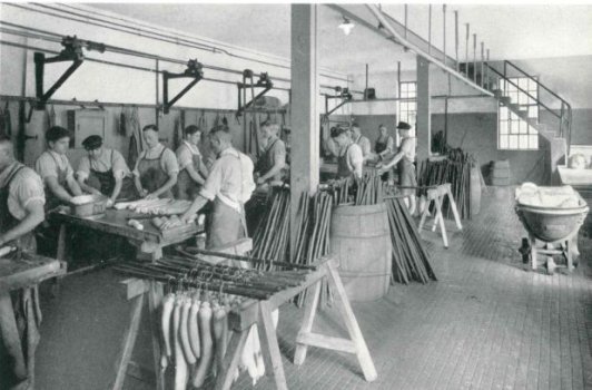 Wiltmann 1937 Schwarz-weiß Foto, das Arbeiter in einer Wurstküche zeigt.