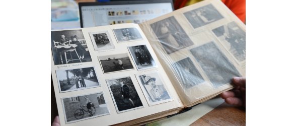 Das Bild zeigt ein aufgeschlagenens Fotoalbum mit alten, beschrifteten Bildern.