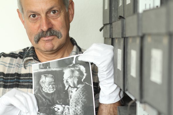 Archivmitarbeiter Thomas Sinnreich mit einem Foto aus dem Nachlass des Malers Peter August Böckstiegel