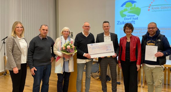 Personen stehen nebeneinander und blicken in die Kamera. 