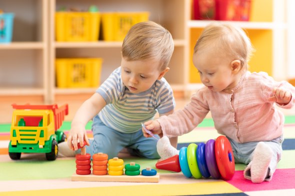 Preschool boy and girl playing on floor with educational toys. Children at home or daycare. Preschool boy and girl playing on floor with educational toys. Children at home or daycare.